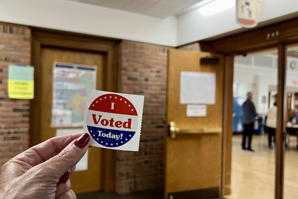 woman holding a sticker that says I voted today 